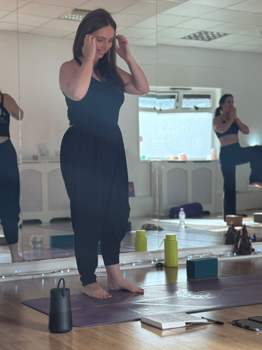 Sally Ashworth teaching a yoga class from the front of a studio